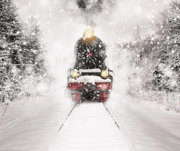 A steam engine train charging down the railways in a snow storm