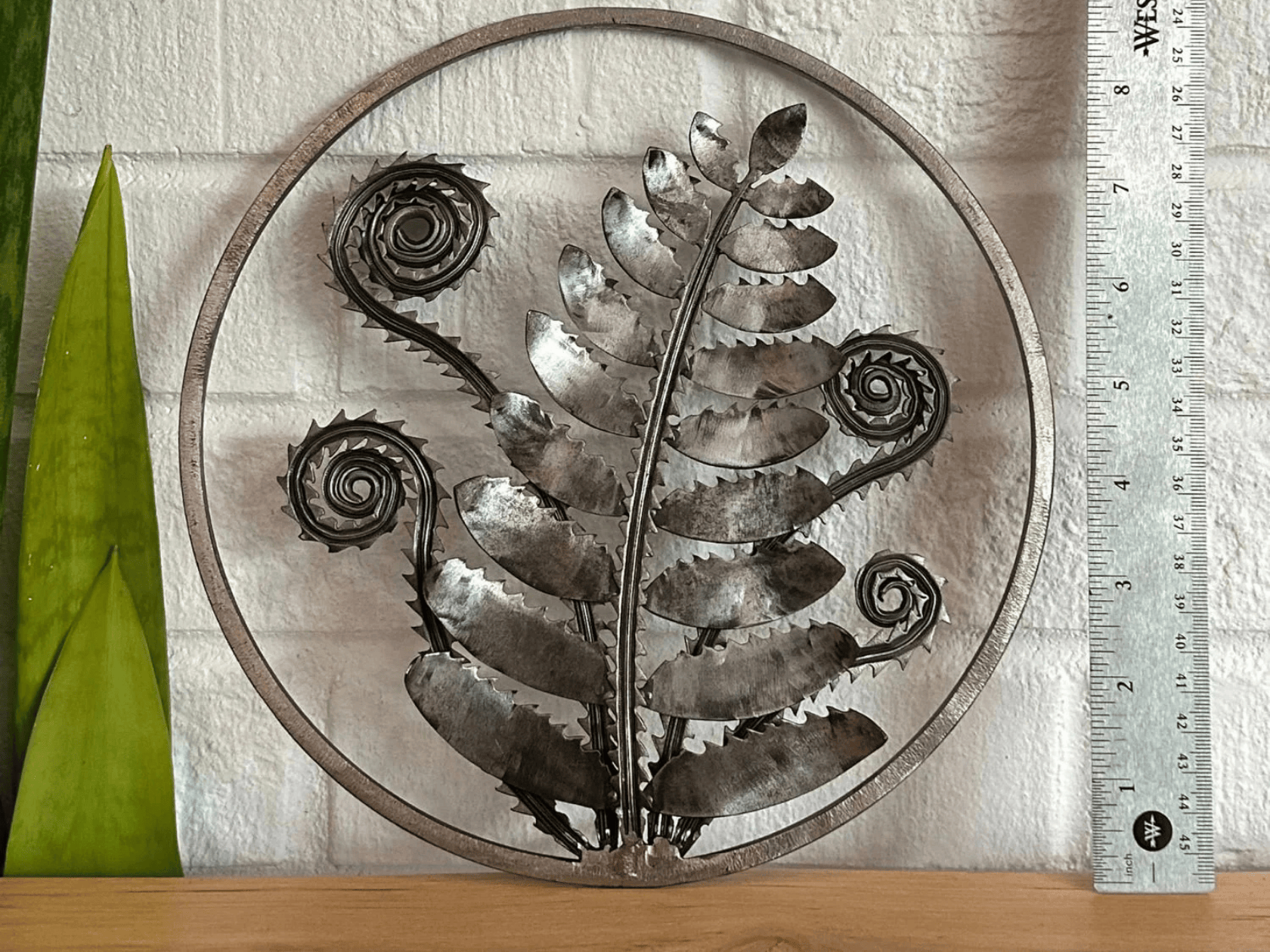 A hand crafted metal wall art of a fern leaf